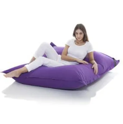 A woman is lying on a large purple beanbag.