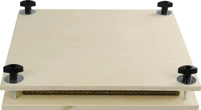 A wooden flower press with four black knobs on top.