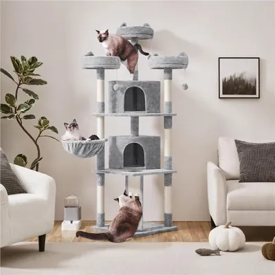 A multi-level cat tree with several cats interacting with it, placed in a living room setting.
