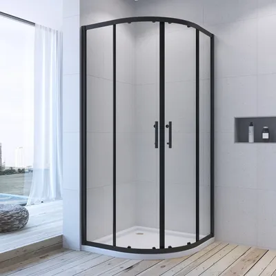 A modern bathroom with a black framed curved glass shower enclosure.