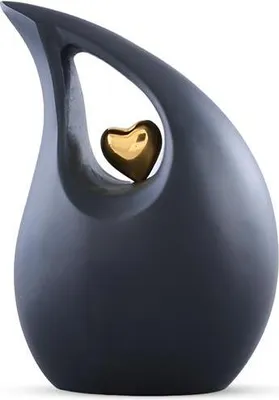 A dark gray, teardrop-shaped urn with a gold heart inside a cutout.