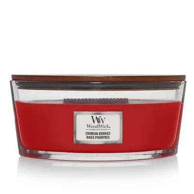 A WoodWick Crimson Berries candle in a clear glass jar with a wooden lid.
