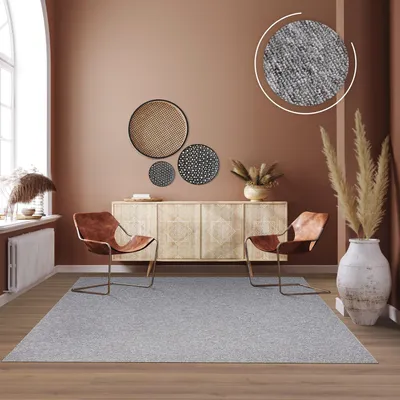 A living room scene featuring a rug, chairs, and a sideboard.