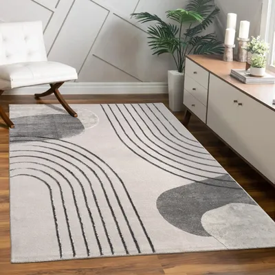 A modern living room with a rug, chair, and cabinet.