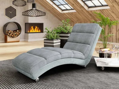 A modern living room with a fireplace, plants, and a chaise lounge.