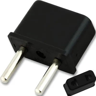 A black electrical adapter with two silver prongs and a separate black adapter piece.