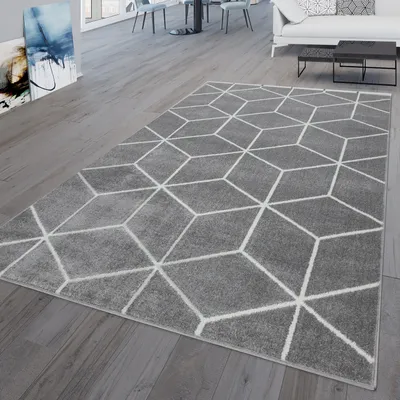 A modern living room with a geometric patterned rug on a wooden floor.