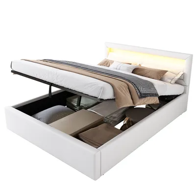 A white bed with storage is shown with the storage compartment open and filled with bedding. The headboard has LED lighting.