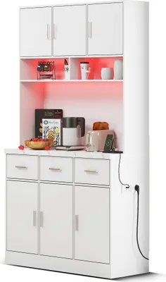 A white kitchen hutch with various kitchen appliances and decor on its shelves and countertop.