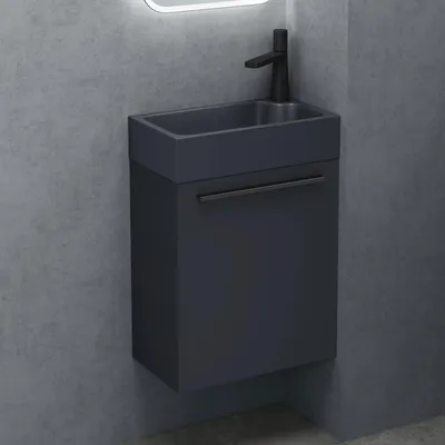 A modern bathroom vanity set with a sink and faucet against a textured gray wall.