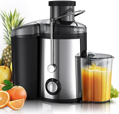 A juicer with fruits and a glass of juice.
