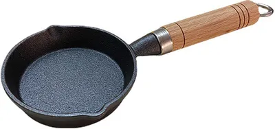 A cast iron mini frying pan with a wooden handle is shown against a white background.