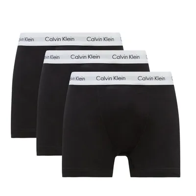 Three black Calvin Klein boxer briefs are arranged in a staggered formation against a white background.