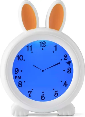A white alarm clock shaped like a bunny with orange ears, displaying the time on a blue digital screen.