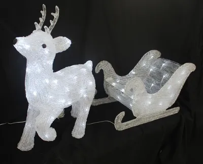 A white LED reindeer and sleigh decoration against a black background.