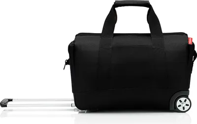 A black duffel bag with wheels and a retractable handle, shown from the side against a white background.