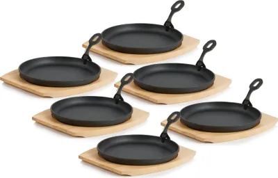 A set of six cast iron serving pans with wooden bases, arranged in a staggered formation against a white background.