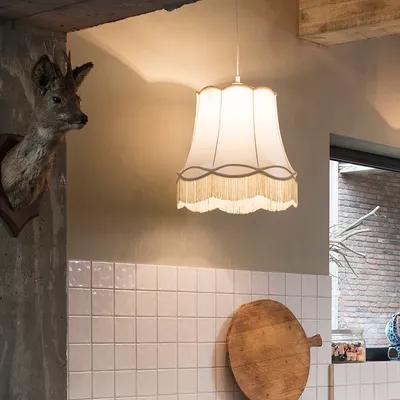 A retro-style pendant lamp hangs in a room with tiled walls and a mounted deer head.