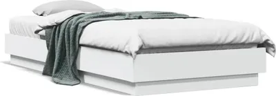 A white bed frame with a mattress, white sheets, and a green blanket.