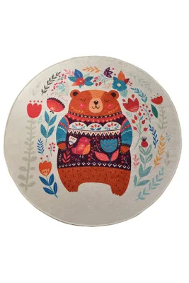 A round rug with a colorful illustration of a bear wearing a sweater, surrounded by flowers and birds.