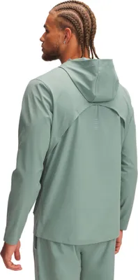A man wearing a green hooded jacket and pants, viewed from the back.