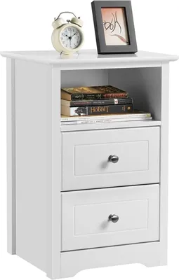A white nightstand with two drawers and an open shelf, displaying books and decorative items on top.