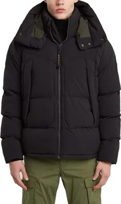 A man wearing a black puffer jacket and green cargo pants.