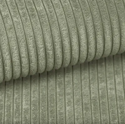 A close-up view of light green corduroy fabric with distinct vertical wales.