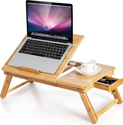 A wooden laptop table with a laptop, a cup, and a small drawer.