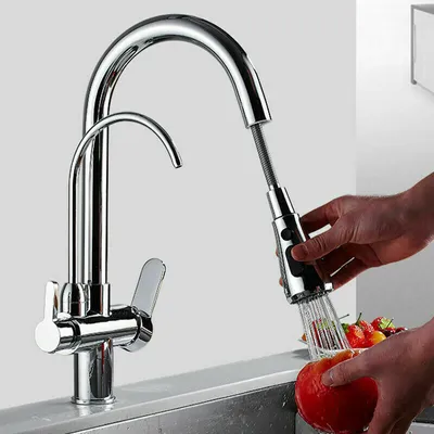A person is washing an apple under a kitchen faucet.