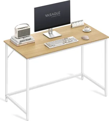 A computer desk with a monitor, keyboard, mouse, and a small speaker on top.
