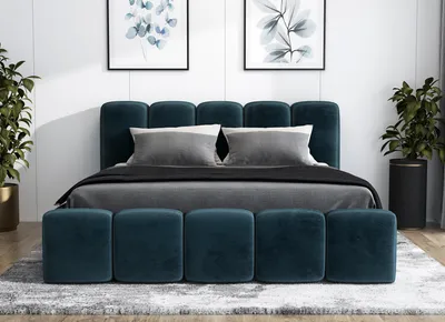 A bedroom scene with a bed and two plants.