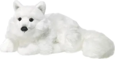 A plush toy arctic fox lying down on a white background.