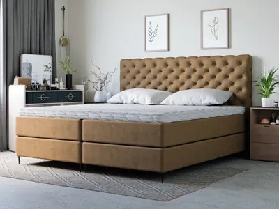 A bedroom scene featuring a tufted upholstered bed with two mattresses.