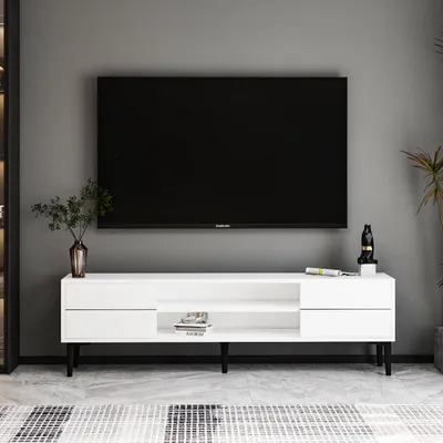 A modern white TV lowboard with black legs is shown in a room with a gray wall and a patterned rug.