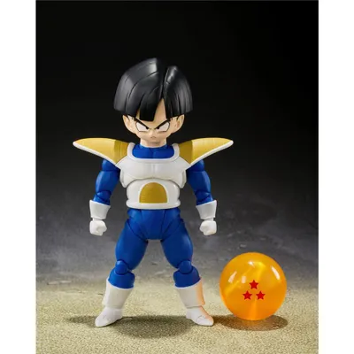 A Dragon Ball Z action figure of Son Gohan in battle clothes stands next to a Dragon Ball with three stars.