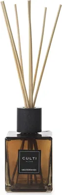 A diffuser with reeds in a brown glass bottle.