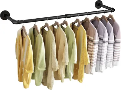 A black metal pipe clothing rack mounted on a white wall, displaying a row of colorful sweaters and cardigans.