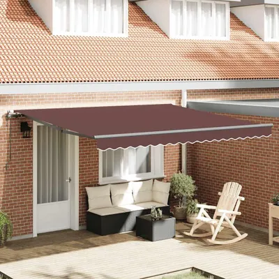 An awning is extended over a patio area with outdoor furniture.