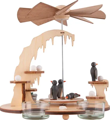 A wooden Christmas pyramid with penguin figures and tea light holders.