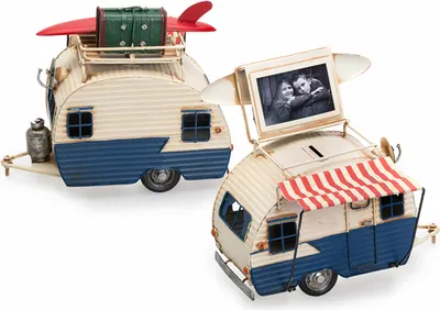 Two decorative metal campers, one with a surfboard and luggage on top, the other with a photo frame and awning.