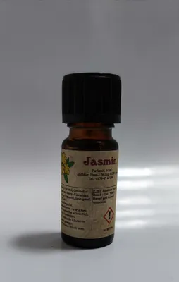 Kleine braune Flasche mit einem schwarzen Verschluss. Auf dem Etikett steht "Jasmin".