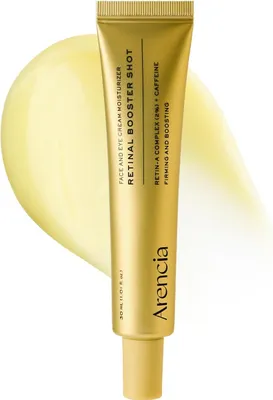 A gold tube of face and eye cream moisturizer with a yellow swatch of cream behind it.