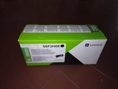 A Lexmark toner cartridge box is placed on a brown tiled floor.