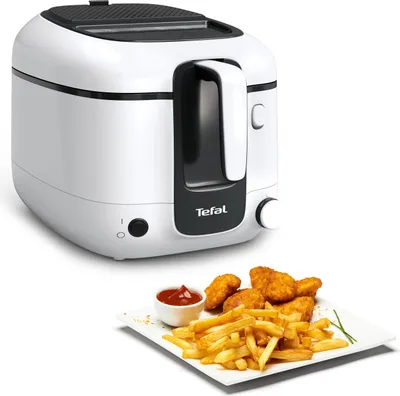 A white Tefal deep fryer is shown next to a plate of french fries and chicken nuggets with a small bowl of ketchup.