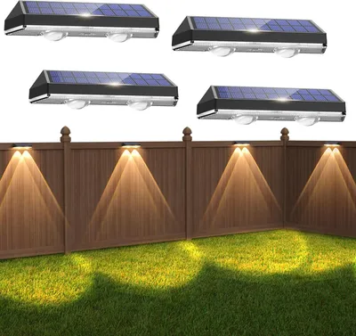 Solar lights mounted on a fence illuminating the lawn below.
