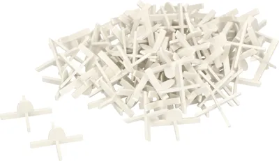 A pile of white tile spacers on a white background.