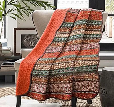 Produktbild von Katoenen Bohemian Slaapdeken mit buntem Streifenmuster und orangefarbenem Hintergrund