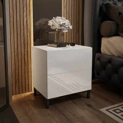 A modern bedroom setting with a white nightstand next to a bed.