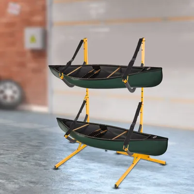 A two-tiered rack holding two green canoes, set in what appears to be a garage or storage area.